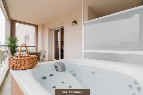 a white bath tub in a bathroom with a basket at Suite Rosso & Nero - Lecce Selection in Lecce