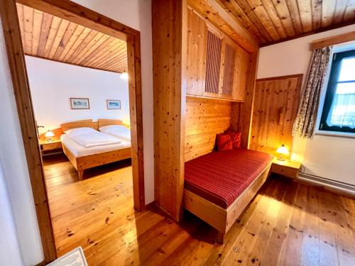 a small room with a bed and a bedroom with a mirror at Ferienhof Stanzl in Rappottenstein