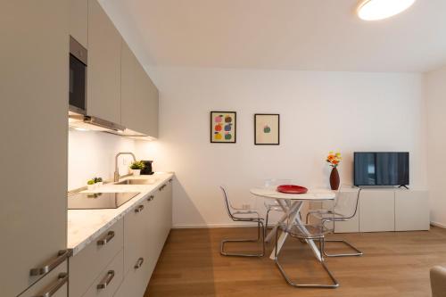 a white kitchen with a table and a sink at Nolo Town Luxury Place in Milan