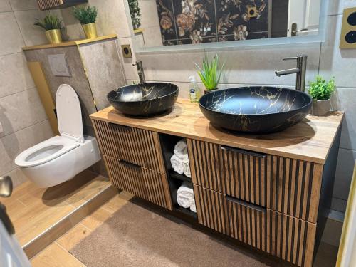 a bathroom with two sinks and a toilet at Serenity's Home in Naintré