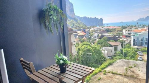 a wooden bench with a potted plant on a balcony at Silk Ao Nang Condominium in Ao Nang Beach