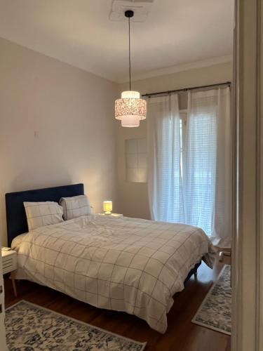 a bedroom with a bed and a chandelier at Urban art House in Eleusis