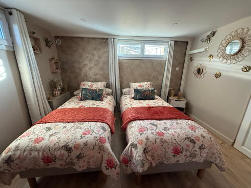 a bedroom with two beds with red blankets at Serenity's Home in Naintré