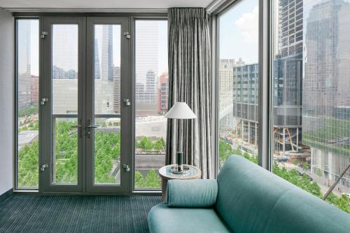 a living room with a blue couch and large windows at World Center Hotel in New York