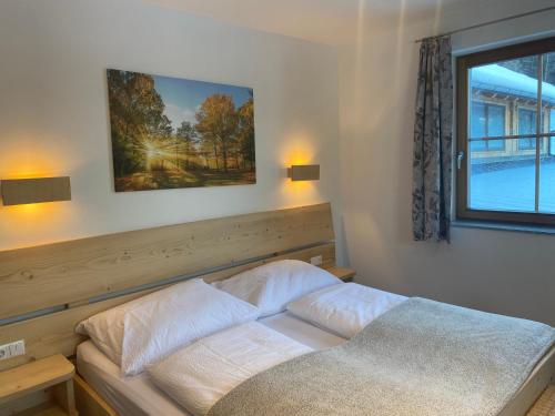 a bed in a bedroom with a picture on the wall at Ferienwohnung Steinacherhof in Arriach