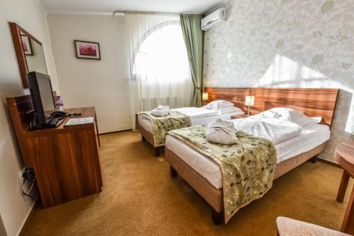 a hotel room with two beds and a television at Wellness hotel Spark in Malacky
