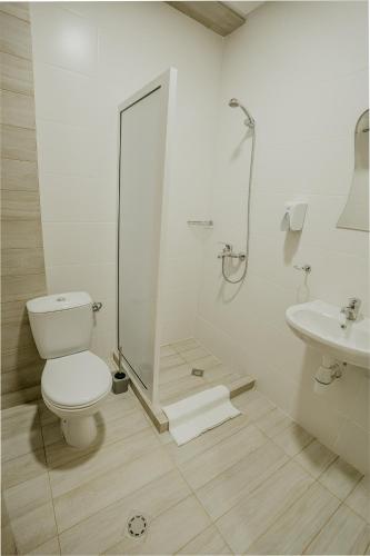 a bathroom with a toilet and a shower and a sink at Port Lake Hotel in Beloslav