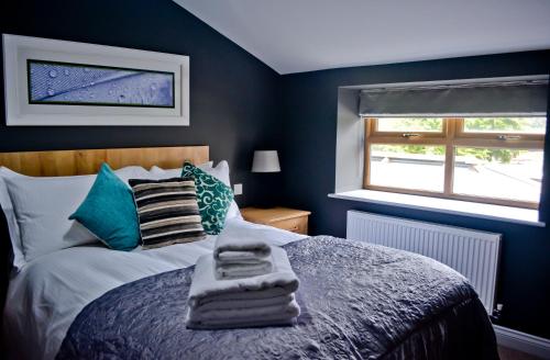 a bedroom with a bed with blue walls and a window at The Ugly Duckling in Telford