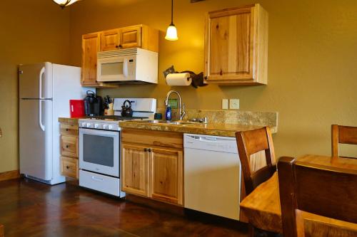 a kitchen with a white refrigerator and a sink at Baycrest Lodge in Homer