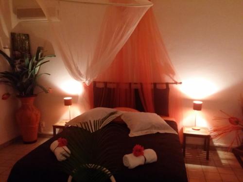 a bedroom with a bed with towels on it at Bungalow PAPAYE in Pointe-Noire