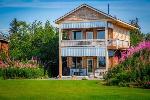 a wooden house with a yard with flowers at Baycrest Lodge in Homer