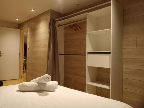 a bedroom with a bed and a closet with towels at Le Bollwiller Piscine Jacuzzi Vignoble in Bollwiller