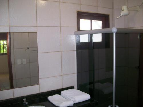 a bathroom with a shower and a sink and a mirror at Privê Maragogi Residence in Maragogi