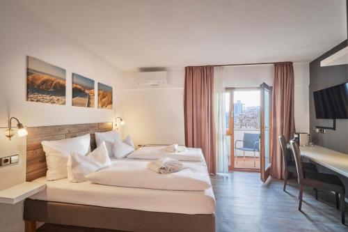 a hotel room with two beds and a desk at Luna Inn Stuttgart City in Stuttgart