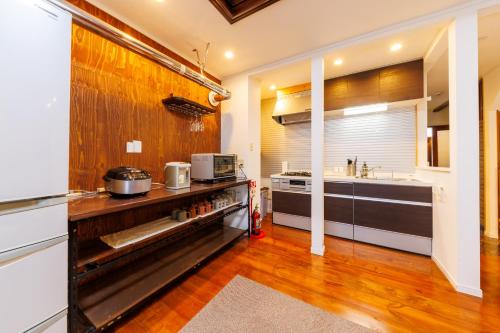a kitchen with a counter with a sink and a stove at Kotoni House in Sapporo