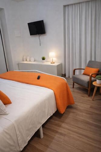 a bedroom with a bed and a tv and a chair at NaMi in Battipaglia