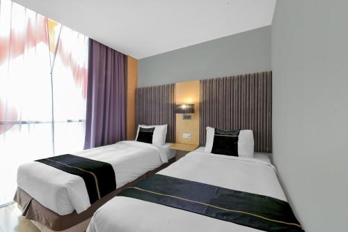 a hotel room with two beds and a window at Sunday Hotel Subang in Subang Jaya