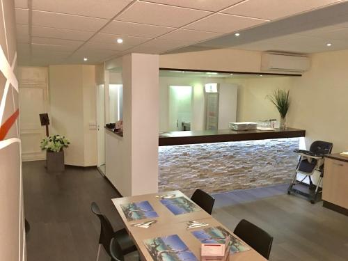 a conference room with a table and a stone wall at Hotel Le Paris in Noumea