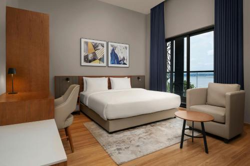 a bedroom with a bed and a couch and a chair at Protea Hotel by Marriott Kinshasa in Kinshasa