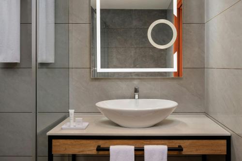 a bathroom with a white sink and a mirror at Protea Hotel by Marriott Kinshasa in Kinshasa