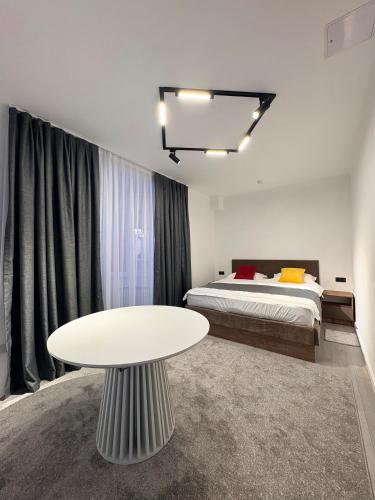 a bedroom with a bed and a white table at Avenue Hotel in Almaty