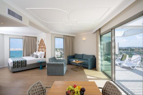 ein Hotelzimmer mit Kingsize-Bett und Wohnzimmer in der Unterkunft Palm Beach Hotel - Mehadrin Kosher suitable for Ultra-Orthodox guests in Akkon
