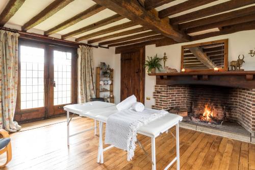 a living room with a table and a fireplace at Aspen Leaves: The perfect farm retreat in Graffham