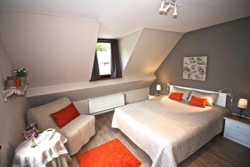 a small bedroom with a bed and a couch at L'O de La Roche in La Roche-en-Ardenne