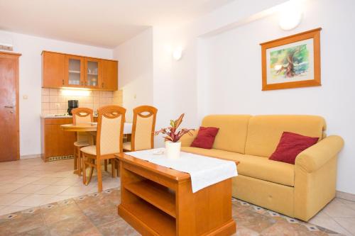 a living room with a couch and a table at Apartments Residence Astoria in Rab