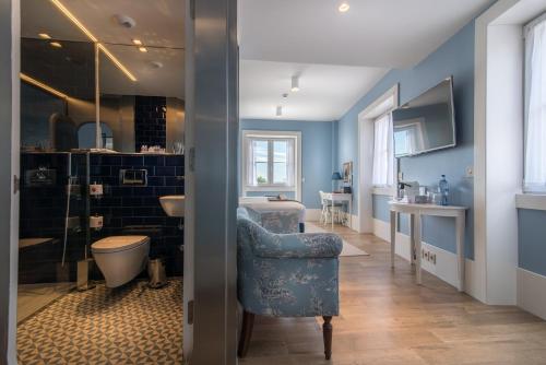 a bathroom with blue walls and a blue chair at Lx Boutique Hotel in Lisbon