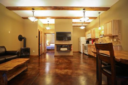 a large living room with a table and a kitchen at Baycrest Lodge in Homer