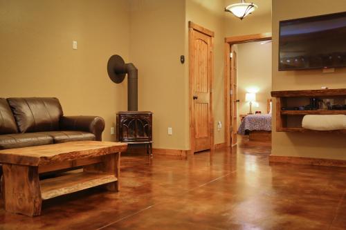 a living room with a leather couch and a fireplace at Baycrest Lodge in Homer