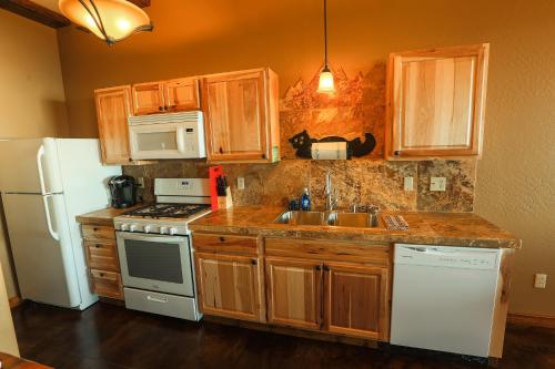 a kitchen with a sink and a white refrigerator at Baycrest Lodge in Homer