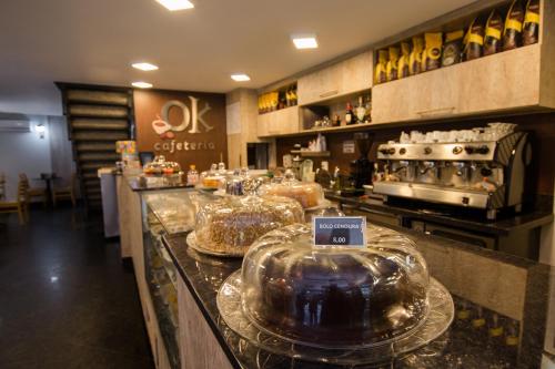 a bakery with several trays of cakes on a counter at Hotel OK in Rio de Janeiro