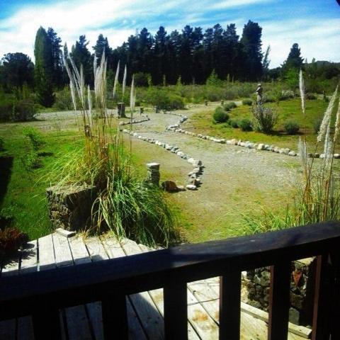 a view of a garden from a balcony at Las Pitras Lodge in Epuyén