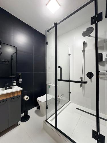 a bathroom with a glass shower and a toilet at Avenue Hotel in Almaty