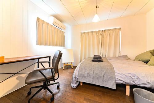 a bedroom with a bed and a desk and a chair at ギャラリーのある宿canvas in Nagoya