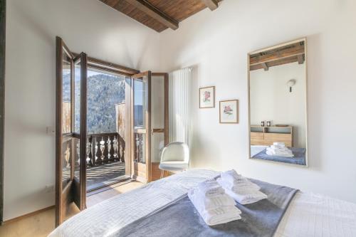 a bedroom with a bed and a large window at Ciasa Remo 2 by WelcHome in San Vito di Cadore