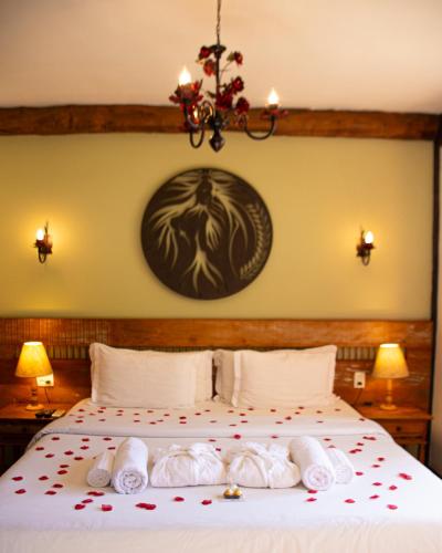 a bedroom with a bed with towels on it at Pousada Chão de Minas in Cachoeira do Campo