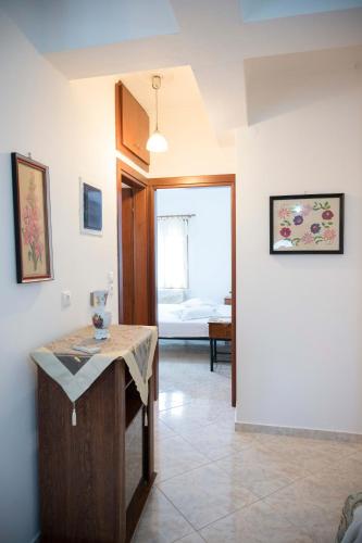 a living room with a table and a bedroom at Lesvos Garden Retreats - Mountain Voyage Residences in Vatoússa