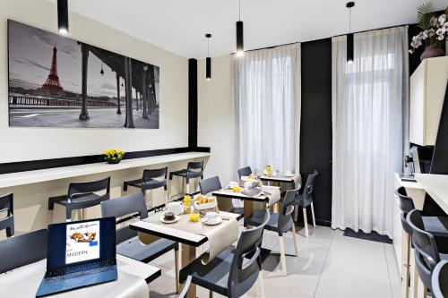 un restaurant avec des tables, des chaises et un ordinateur portable dans l'établissement Modern Hotel, à Paris