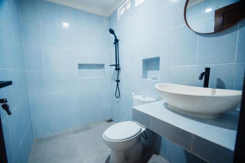 a bathroom with a sink and a toilet and a mirror at Tiny House Nusa Lembongan in Nusa Lembongan