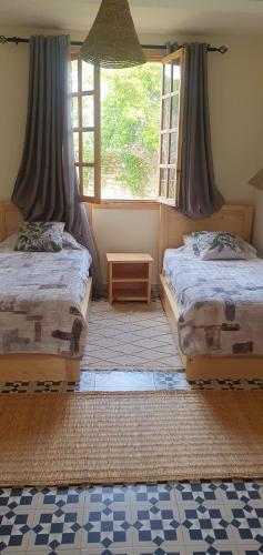 a bedroom with two beds and a large window at Villa Assalama Mogador, Essaouira in Essaouira