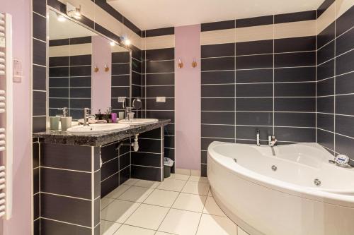 a bathroom with two sinks and a bath tub at Le Domaine de Rose in Lourdes
