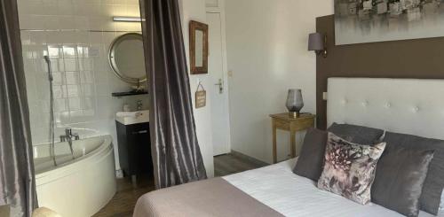 a bedroom with a bed and a bath tub and a sink at Hôtel de la Plage in Narbonne