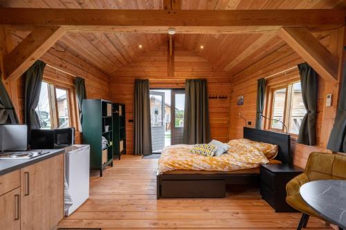 a bedroom with a bed in a wooden room at Vakantiehuisje Appel & Fleur in Swalmen