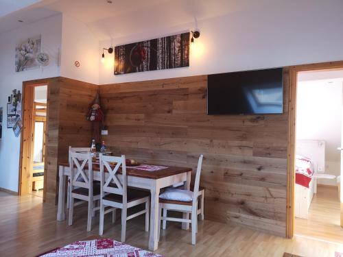 a dining room with a wooden wall with a table and chairs at Ankommen und loswandern Familien und Hundeurlaub im Hochschwarzwald Ferienwohnung Haus Maria in St. Blasien