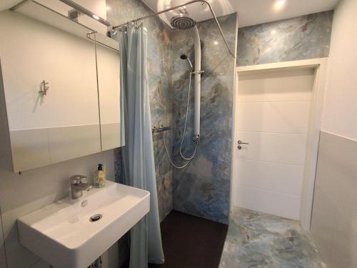 ein Badezimmer mit Waschbecken und Dusche in der Unterkunft FeWo Bodo in Freisen