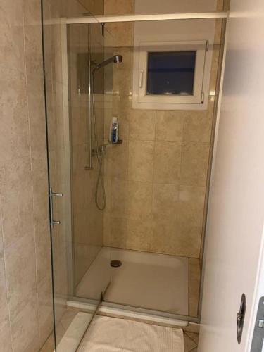 a shower with a glass door in a bathroom at Grande chambre avec Salle de Bains Privative in Lausanne
