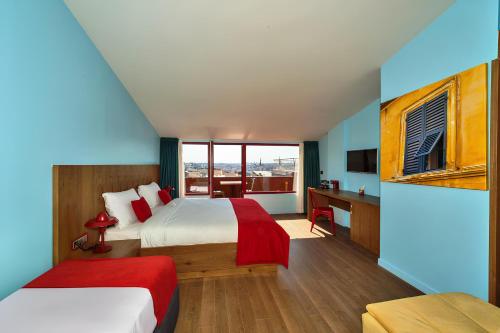 a hotel room with two beds and a desk and a window at Taksim Istanbul Nis Hotel - Istiklal Street in Istanbul
